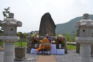 碑に経をささげる牛額寺住職